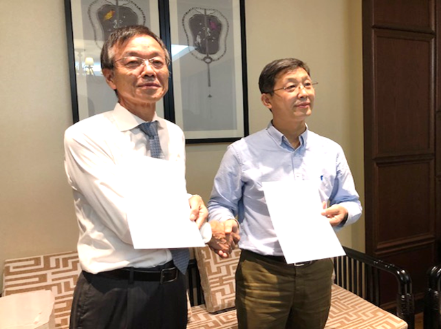 Liu薬学院長と宇根薬学部長（調印後の夕食会で協定書を手に記念撮影）